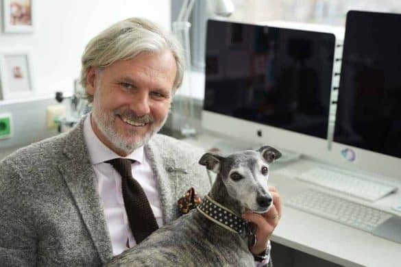 Helmut Jungwirth sitzt mit seinem Hund Woody in seinem Büro.