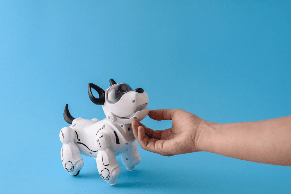 Ein Roboterhund und eine Hand vor einem blauen Hintergrund.