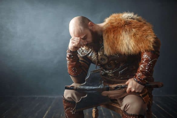 Sad viking with axe sitting on chair