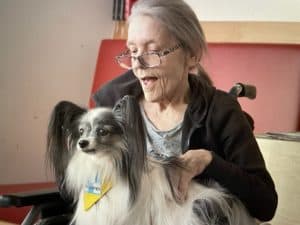 Heimbewohnerin mit einem Therapiehund von TAT. Fit und aktiv mit tiergestützter Intervention. /Foto: TAT